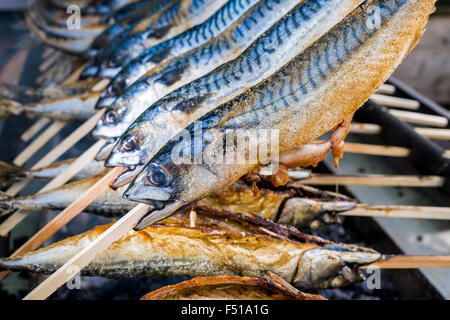 Stockfisch, ein Fischgericht auf einem Holzstab vorbereitet, ist vom Grill auf einem Grill Stockfoto