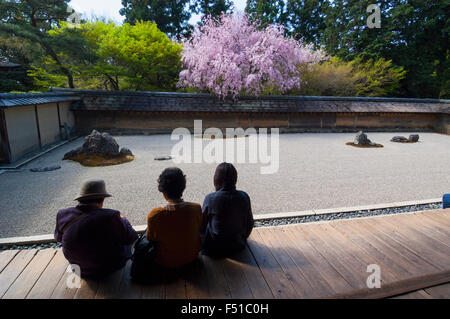 Drei Besucher betrachten berühmten trockenen Garten in Ryoanji-Tempel in Kyoto Japan Stockfoto