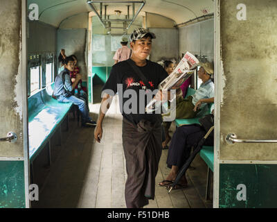 Yangon, Yangon Division, Myanmar. 26. Oktober 2015. Ein Zeitung-Anbieter führt durch den Yangon kreisförmigen Zug. Die Yangon kreisförmigen Bahn ist das lokale Pendler Schienennetz, das das Stadtgebiet von Yangon dient. Von Myanmar Railways betrieben, verbindet die 45.9 Kilometer (28.5Â Meile) 39-Station-Loop-System Satellitenstädte und vorstädtischen Gebieten in die Stadt. Die Bahn hat rund 200 Trainer, 20 Mal täglich läuft und täglich 100.000 bis 150.000 Tickets verkauft. Die Schleife, die etwa drei Stunden dauert, ist ein beliebtes für Touristen zu sehen, einen Querschnitt des Lebens in Yangon. Die Züge verkehren von 03:45 Stockfoto