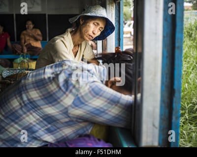 Yangon, Yangon Division, Myanmar. 26. Oktober 2015. Passagiere schlafen auf den Yangon kreisförmigen Zug. Die Yangon kreisförmigen Bahn ist das lokale Pendler Schienennetz, das das Stadtgebiet von Yangon dient. Von Myanmar Railways betrieben, verbindet die 45.9 Kilometer (28.5Â Meile) 39-Station-Loop-System Satellitenstädte und vorstädtischen Gebieten in die Stadt. Die Bahn hat rund 200 Trainer, 20 Mal täglich läuft und täglich 100.000 bis 150.000 Tickets verkauft. Die Schleife, die etwa drei Stunden dauert, ist ein beliebtes für Touristen zu sehen, einen Querschnitt des Lebens in Yangon. Die Züge fahren von 03:45 bis 10:15 Stockfoto