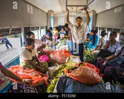 Yangon, Yangon Division, Myanmar. 26. Oktober 2015. Ein Dirigent versucht, durch einen überfüllten Yangon kreisförmigen Zug gehen. Die Yangon kreisförmigen Bahn ist das lokale Pendler Schienennetz, das das Stadtgebiet von Yangon dient. Von Myanmar Railways betrieben, verbindet die 45.9 Kilometer (28.5Â Meile) 39-Station-Loop-System Satellitenstädte und vorstädtischen Gebieten in die Stadt. Die Bahn hat rund 200 Trainer, 20 Mal täglich läuft und täglich 100.000 bis 150.000 Tickets verkauft. Die Schleife, die etwa drei Stunden dauert, ist ein beliebtes für Touristen zu sehen, einen Querschnitt des Lebens in Yangon. Die Züge verkehren fr Stockfoto