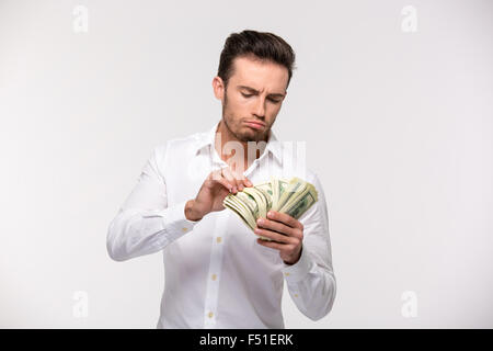 Porträt eines jungen Mannes Geldzählen isoliert auf weißem Hintergrund Stockfoto