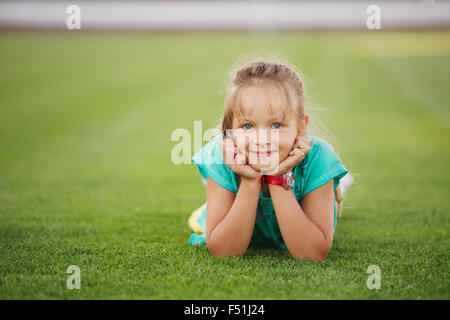 kleine lustige Mädchen auf Fußballstadion Stockfoto