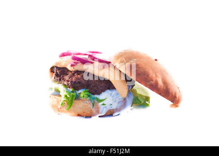 Hausgemachte Hamburger, gebildet von gehacktem Rindfleisch, Cheddar-Käse, roten Zwiebeln, Salat und Tsaziki, isoliert auf weißem Hintergrund Stockfoto