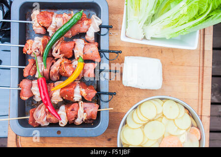 Fleischspieße, Speck und Schweinefleisch, in der Nähe von Römersalat, Chili, Halloumi und Süßkartoffeln gemacht Stockfoto