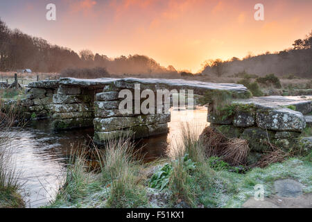 Frostigen Winter Sonnenaufgang über einer alten Granit Klöppel Brücke bei Postbridge auf Dartmoor Stockfoto