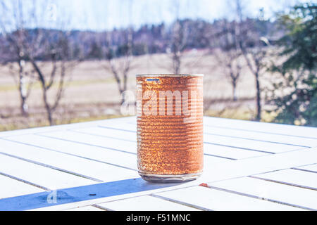 Einsame Rusty kann auf einem weißen Tisch Stockfoto