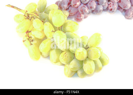 Eine Reife grüne Trauben vor lila Trauben, isoliert auf weißem Hintergrund Stockfoto