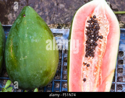 Ganze und eine halbe, grün Carica Papaya Frucht Stockfoto