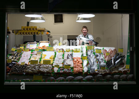 Ein Fischhändler in seinem Stall in Leeds Kirkgate Market in West Yorkshire, Großbritannien.  Es ist der größte überdachte Markt in Europa. Stockfoto