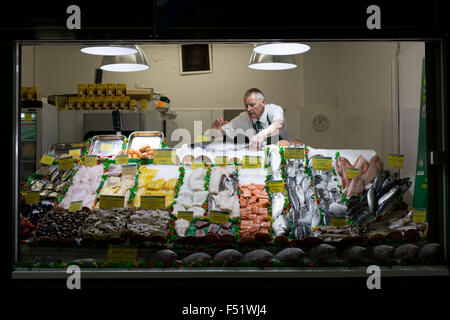 Ein Fischhändler in seinem Stall in Leeds Kirkgate Market in West Yorkshire, Großbritannien.  Es ist der größte überdachte Markt in Europa. Stockfoto