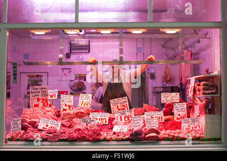 Ein Metzger in seinem Stall in Leeds Kirkgate Market in West Yorkshire, Großbritannien.  Es ist der größte überdachte Markt in Europa. Stockfoto