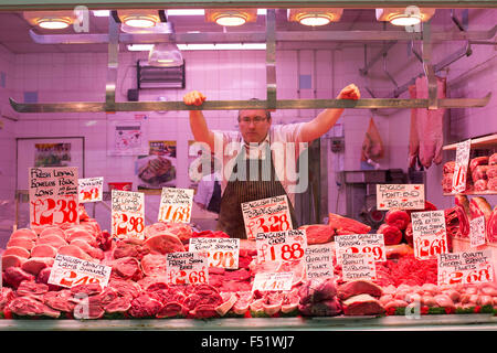 Ein Metzger in seinem Stall in Leeds Kirkgate Market in West Yorkshire, Großbritannien.  Es ist der größte überdachte Markt in Europa. Stockfoto