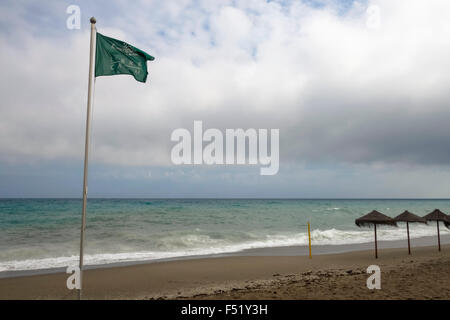 Grüne Flagge, mediterranen Strand mit Sonnenschirmen bei schlechtem Wetter, Spanien. Stockfoto