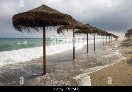 Strand mit Sonnenschirmen bei schlechtem Wetter, Spanien am Mittelmeer. Stockfoto