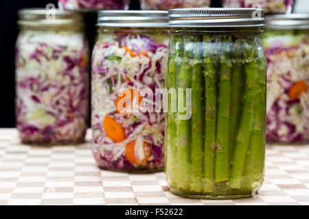 Hausgemachte fermentierte Spargel mit Gläser mit Kohl und Karotten im Hintergrund Stockfoto