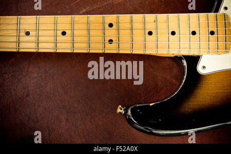 E-Gitarre Körperteil mit Kratzern und Hals Detail auf hölzernen Hintergrund, Vintage-look Stockfoto