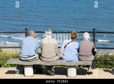 Ältere Paare sitzen auf Sitzplatz mit Blick auf das Meer. UK Stockfoto