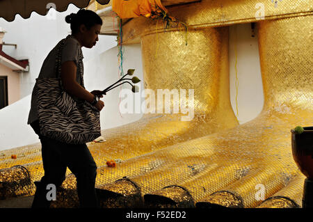 Junge Frau am Fuße des 32 Meter hohen stehenden Buddha-Statue im Wat Intharawihan, Bangkok, Thailand Stockfoto