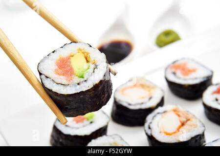 Nahaufnahme eines Tabletts mit einigen verschiedenen Makizushi, gefüllt mit Garnelen, oder Thunfisch, Avocado und Krabben Fleisch Stockfoto