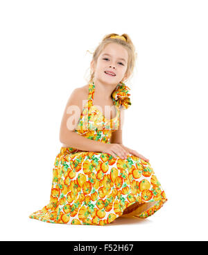 Kleines Mädchen in einem gelben Kleid posiert auf weißem Hintergrund Stockfoto