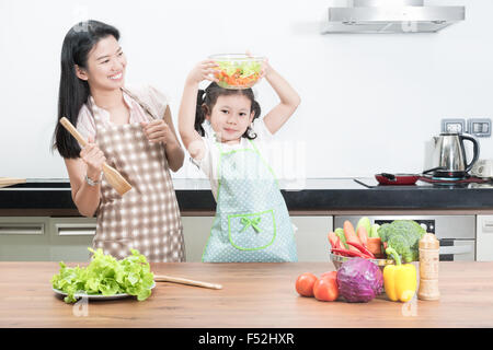 Familie, Kinder und glückliche Menschen Konzept - Asiatisch Kochen in der Küche zu Hause Tochter von Mutter und Kind Stockfoto