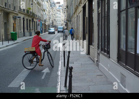 Frau in Rot, ein Fahrrad im Marais, Paris FR Stockfoto