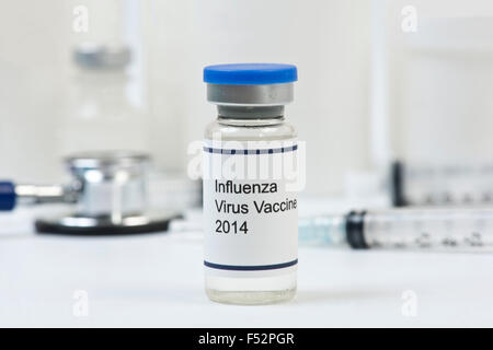 2014 Influenza-Impfstoff Fläschchen mit Office liefert im Hintergrund. Stockfoto