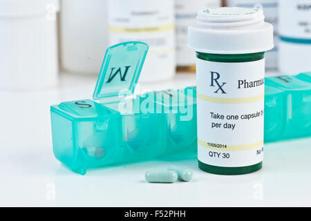 Täglichen Medikamenten-Dispenser mit grünes Rezept Flasche und Pillen. Stockfoto
