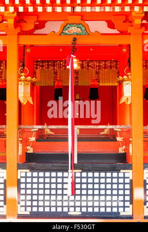 Kyoto Fushimi Inari Shinto Schrein. Vor main vermillion Hall, bell Seil in und Darunter hängen, die tamagaki, Zaun schutz Schrein. Stockfoto