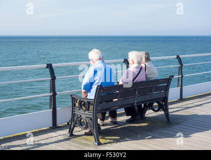 Ältere Menschen sitzen auf Sitz auf Saltburn Pier. Saltburn von Meer, England, UK Stockfoto