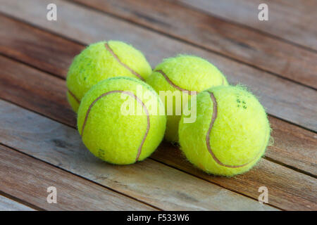 Vier Tennisbälle isoliert auf einem Holztisch, selektiven Fokus Stockfoto