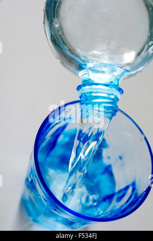 Wasser aus der Flasche ins Glas Stockfoto