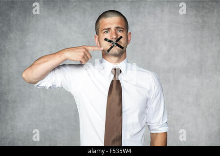traurig Geschäftsmann zeigen mit dem Finger die Band Hexe Block seinen Mund Stockfoto