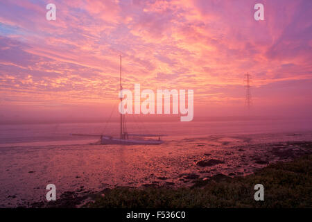 Creek Faversham, Kent, UK. 27. Oktober 2015: UK Wetter. Dramatische Farben im Nebel kurz vor Sonnenaufgang bei Ebbe in Faversham Bach über die alten Whitstable Auster Yawl F76 Gamecock. Sie ist über 100 Jahre alt und einer der nur eine Handvoll dieser Boote verlassen flott. Das trockene Wetter soll weichen für Regen Mittwoch Credit: Alan Payton/Alamy Live News Stockfoto