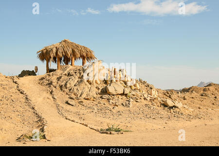 Traditionelle afrikanische Schilf und Stroh Hut und Berg Kulturlandschaft auf den Hintergrund. Stockfoto