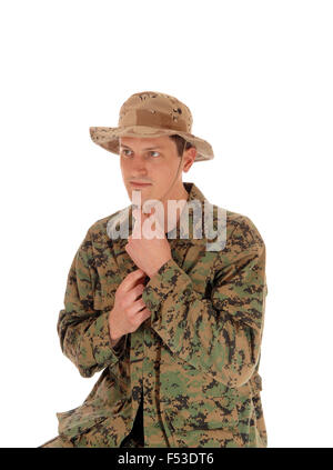 Ein junger Soldat sitzt für weißen Hintergrund mit Camouflage uniform und Beige Hut, weißen Hintergrund isoliert. Stockfoto