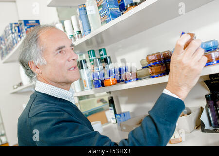 Mann in seinem Laden Regale Stockfoto