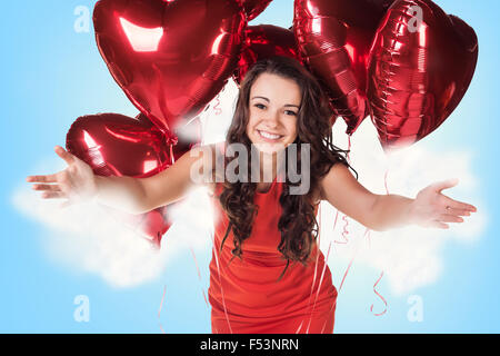 Junge Frau im roten Kleid mit Luftballons Stockfoto