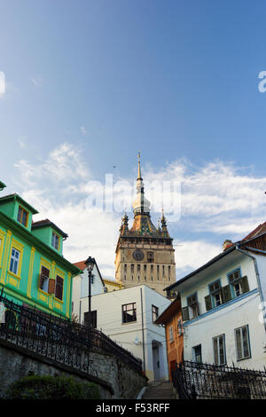 Uhrturm einseitig durch alte Gebäude innen mittelalterliche Stadt von Sighisoara/Schäßburg, Siebenbürgen, Rumänien Stockfoto