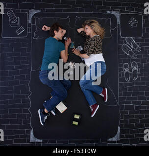 Junges Paar beim Einschlafen beim Spielen ein Brettspiel in einem Schlafzimmer eingezeichnet mit Kreide auf Papier. Stockfoto