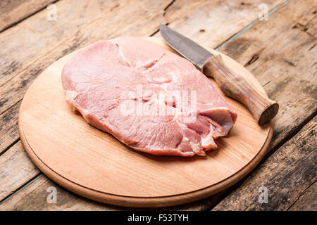 Großen Beefsteak mit ländlichen Messer auf Holztisch. Stück frisches rohes Fleisch vor dem Kochen Stockfoto