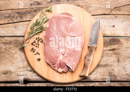 Großes Stück Fleisch mit Kräutern und Paprika auf Schneidebrett. Ansicht von oben Bild rohes frisches Rindfleisch Steak Stockfoto