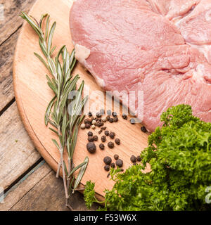 Schließen Sie herauf Bild von Rindersteak mit Kräutern und Gewürzen auf Holzbrett Stockfoto