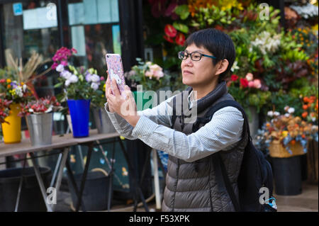 Touristen mit Smartphone zum Fotografieren auf der La Rambla in Barcelona Katalonien Spanien ES Stockfoto