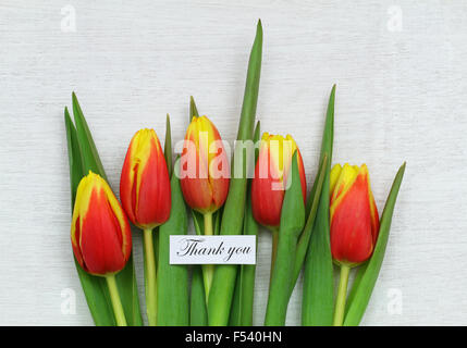 Dankeschönkarte mit roten und gelben Tulpen auf weißem Holz Stockfoto