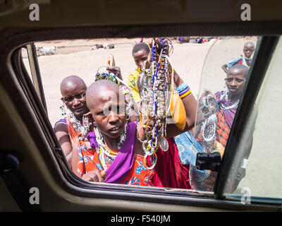 Massai-Frauen bieten Souvenirs an Touristen durch ein Autofenster in Arusha Region, Tansania, Afrika. Stockfoto