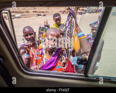 Massai-Frauen bieten Souvenirs an Touristen durch ein Autofenster in Arusha Region, Tansania, Afrika. Stockfoto