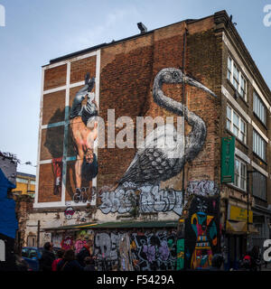 Touristen auf der Suche Graffiti in der Hanbury Street, off Brick Lane im East End von London. Stockfoto