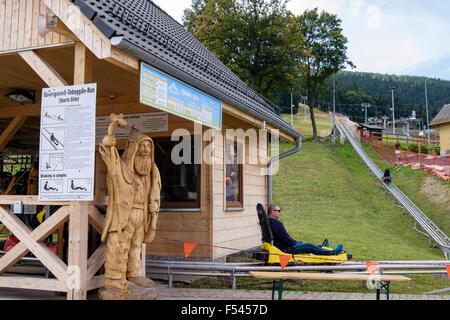 Mann auf Sommer Rodelbahn Run Sport Folie im Skigebiet Czarna Gora (schwarzer Berg) im Snieznicki Park Stobrawski. Polen Stockfoto